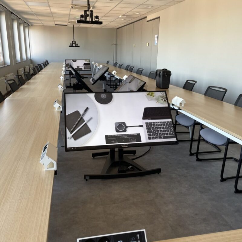 Salle de réunion lumineuse avec grand écran de présentation, des projecteurs vidéo et des caméras individuelles